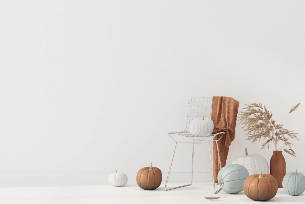 painted pumpkins and a chair draped with a blanket