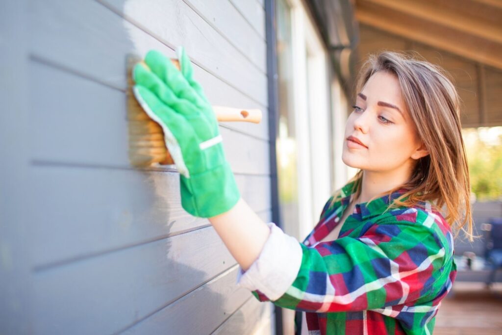 woman painting an exterior wall