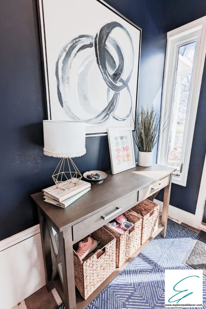 entryway console with large art print and shoe storage baskets