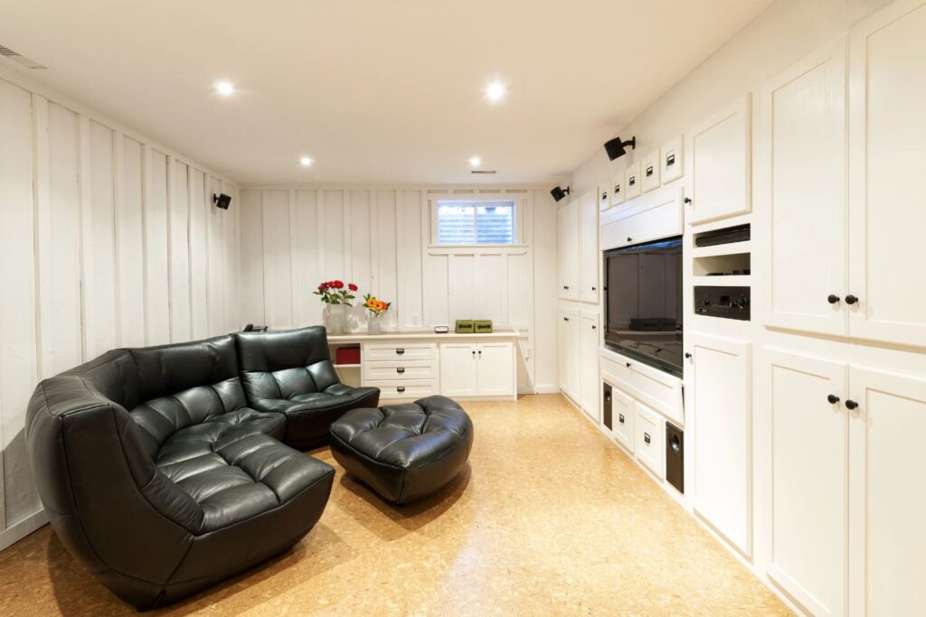 dark basement entertainment area with painted cabinets