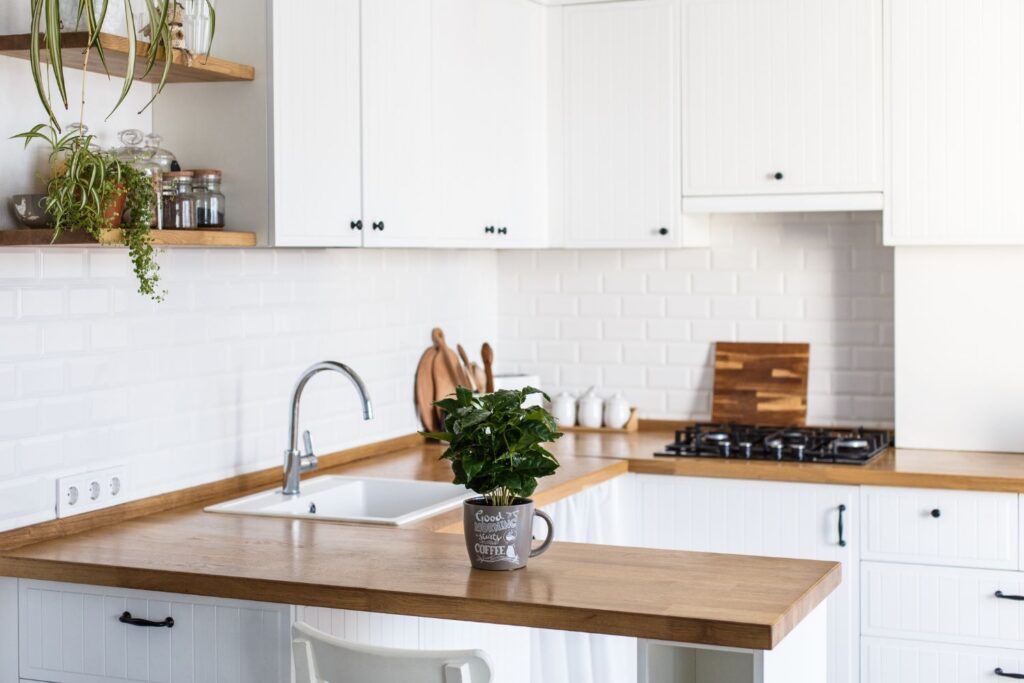 small kitchen with white cabinets and wood countertop