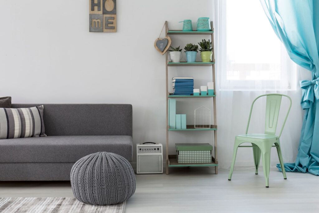 living room with sofa, shelf, chair, and chunky textured ottoman